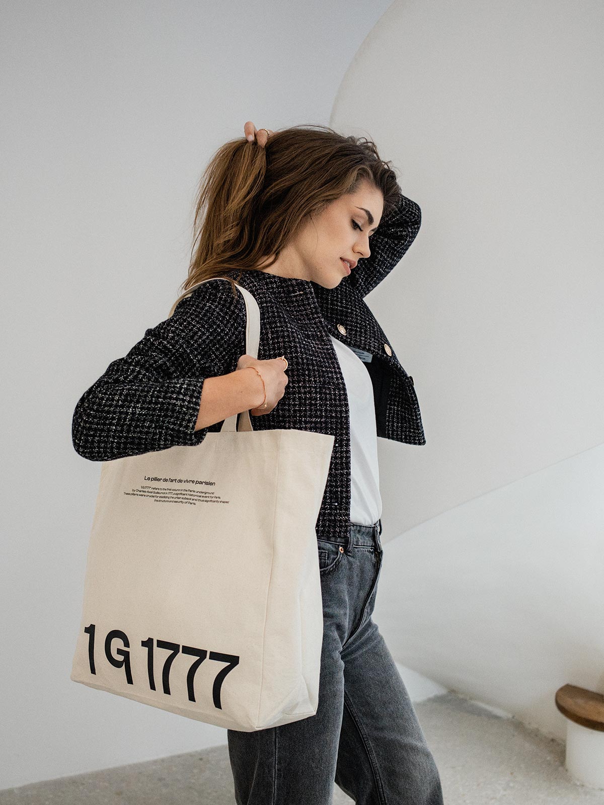 Model in an all-white Parisian atelier with the Rosenstaub 1G1777 Canvas Tote Bag, highlighting its elegant design and Parisian inspiration.