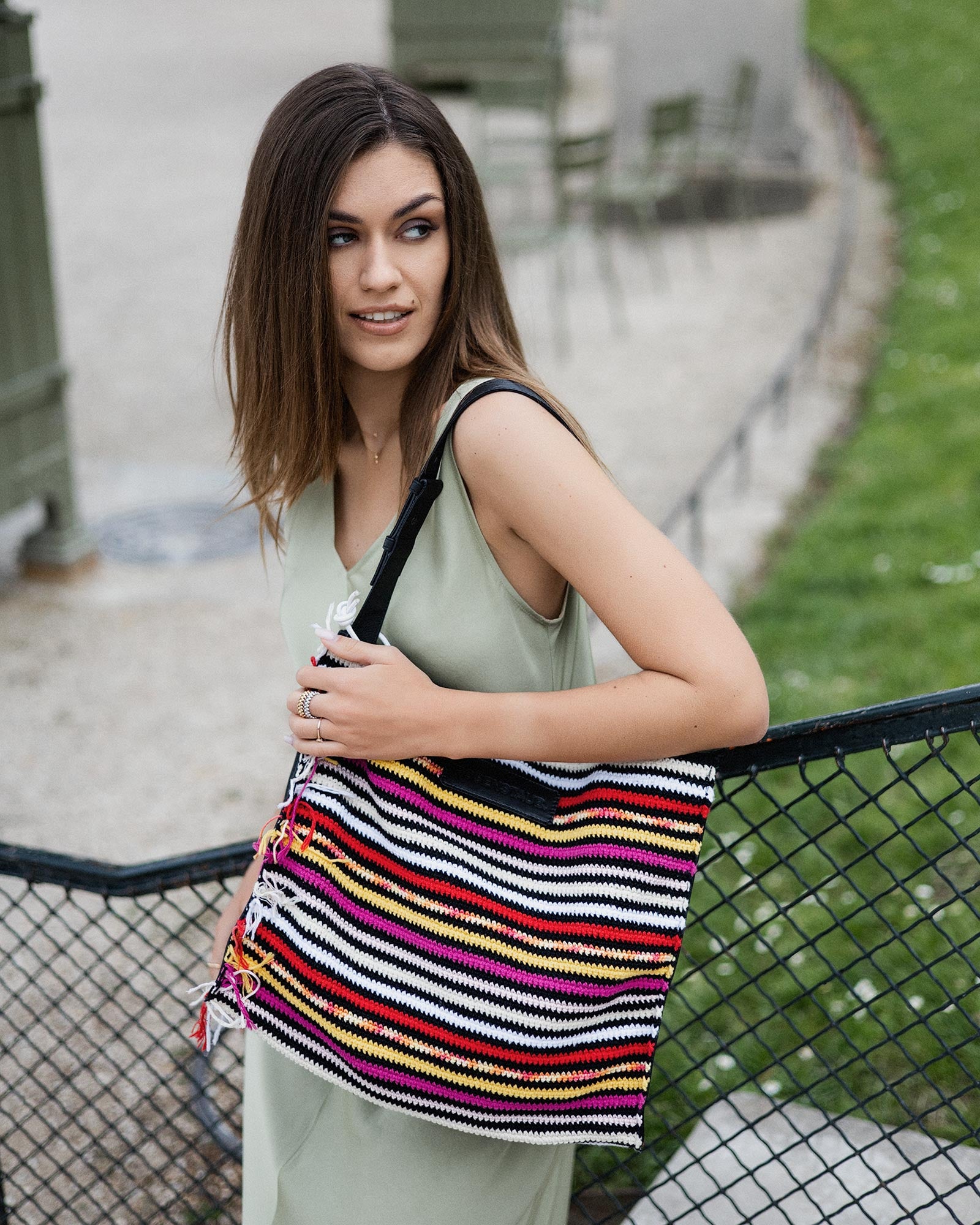 Model wearing the Rosenstaub Crochet Shopper No. 20 of 30 in a park in Paris, featuring colors pink, red, yellow, and white