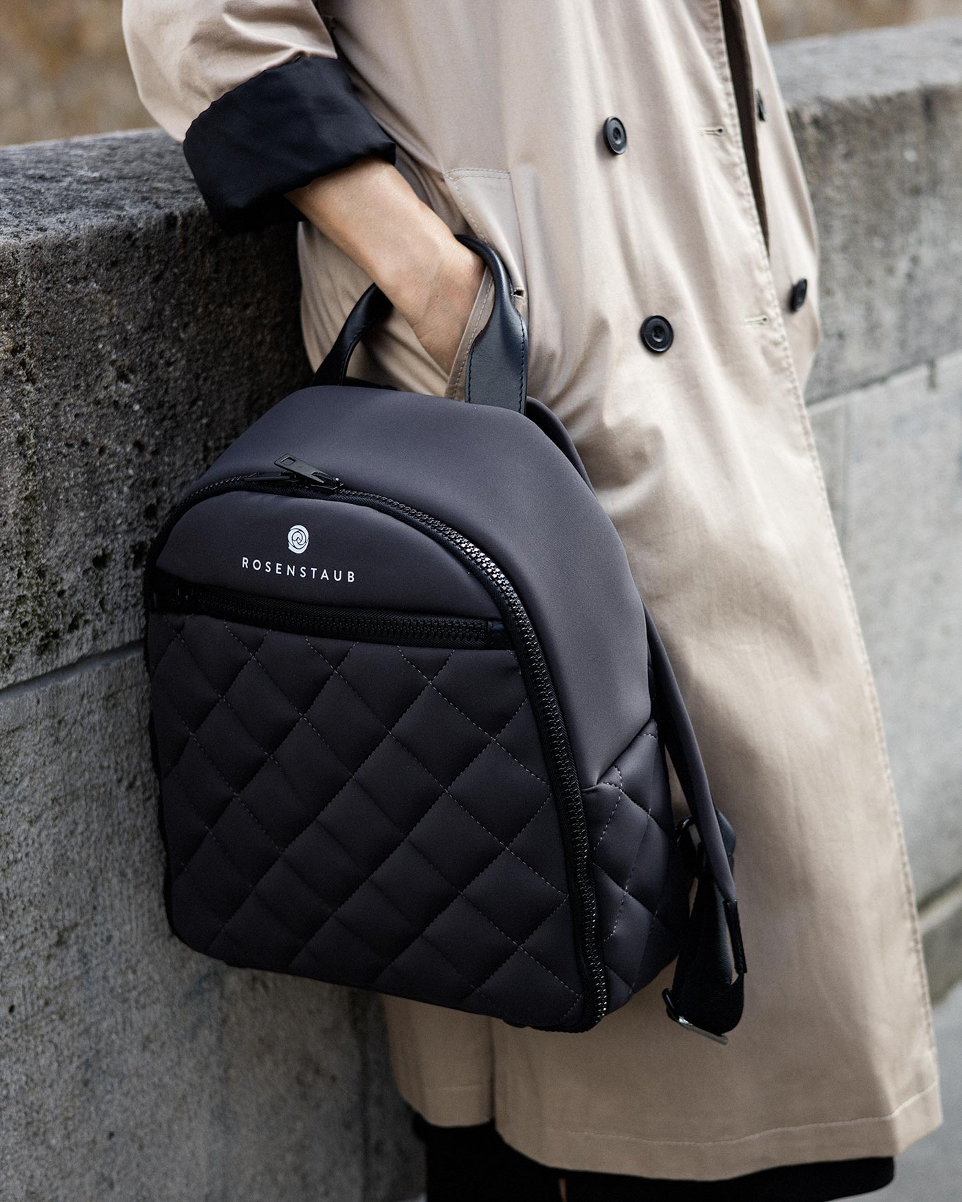 Close-up of Rosenstaub's grey backpack draped casually over the wrist of a woman