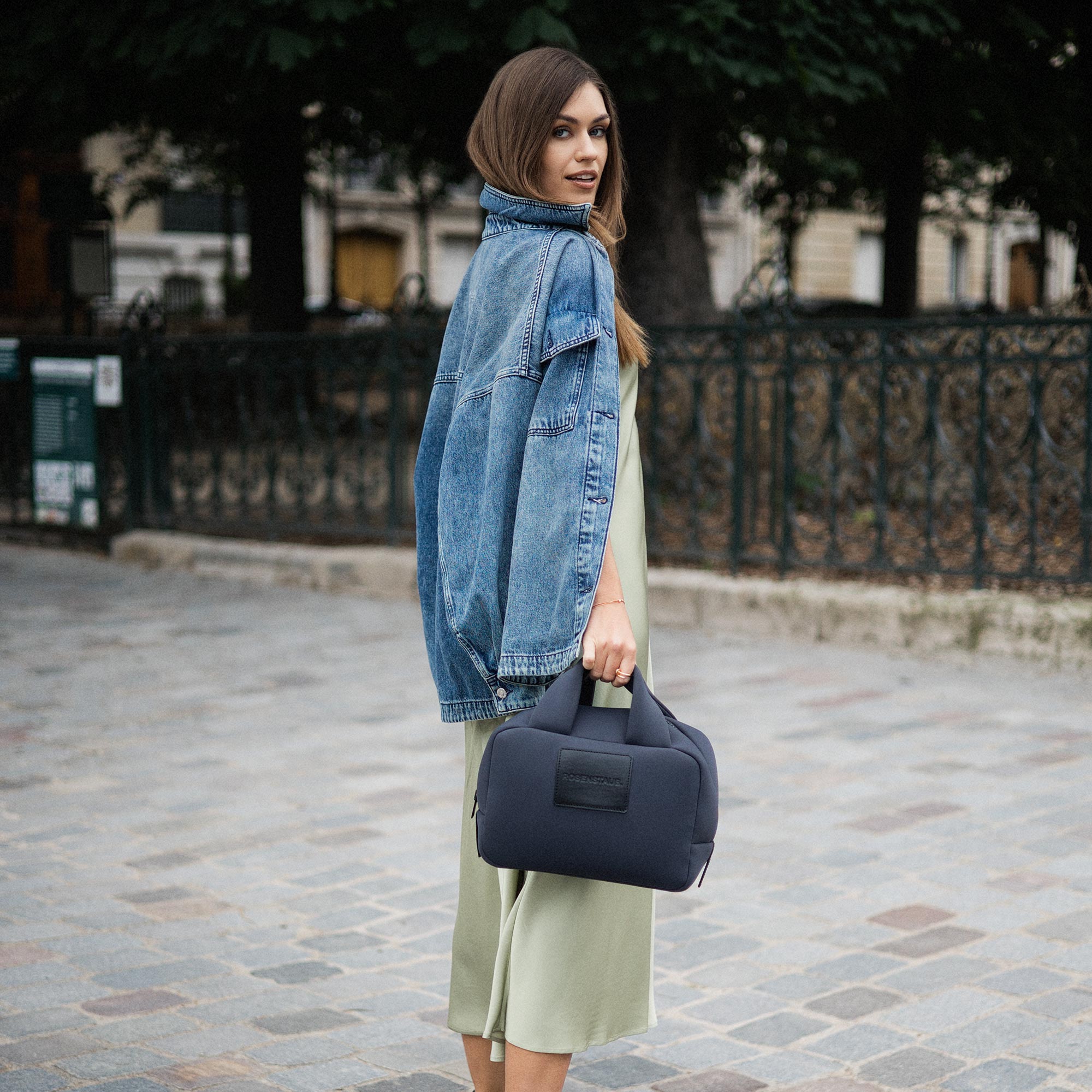 Model wearing the Rosenstaub grey Bauletto bag in a park in Paris, showcasing its elegant design and casual-chic style.