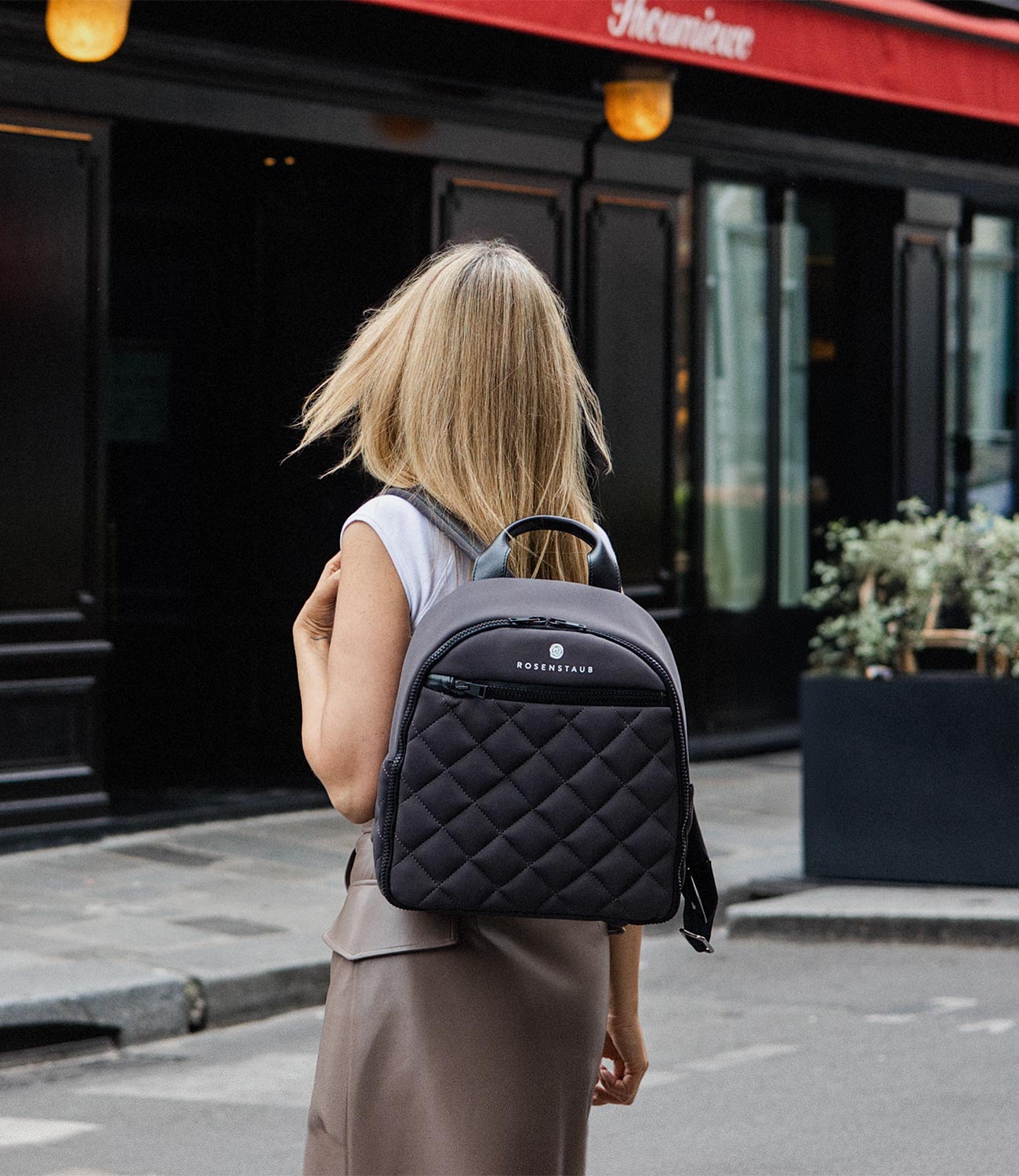 Model wearing a grey neoprene backpack by Rosenstaub on a street in Paris, highlighting a stylish and urban design